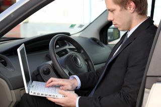 Foto: Mann mit Laptop im Auto